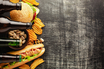 bottle of beer and different snacks on rustic wooden table. Top view