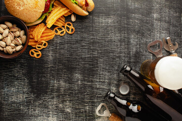 bottle of beer and different snacks on rustic wooden table. Top view