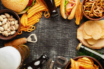 bottle of beer and different snacks on rustic wooden table. Top view