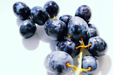 Dark blue grape with leaves isolated on white background. Wet fruit. With clipping path. Full depth...