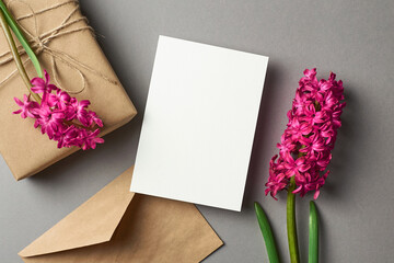 Greeting or invitation card stationary mockup with envelope, gift box and fresh hyacinth flowers on...