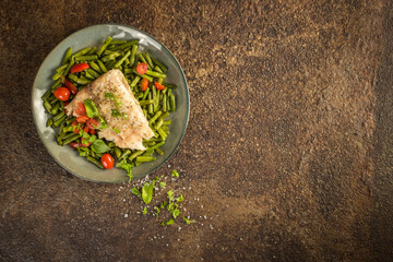 Alaskan pollock fillet with steamed green beans on a rusty metal background with copy space, top view - obrazy, fototapety, plakaty