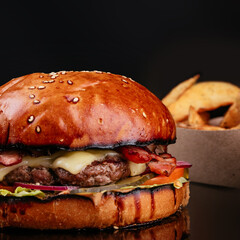 Juicy and sliced ​​burger with meat cutlet close up. on a black background.