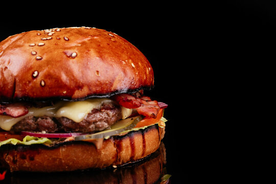 Juicy and sliced ​​burger with meat cutlet close up. on a black background.