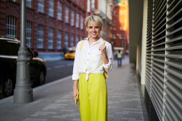 Half length portrait of happy hipster girl with mobile technology in hand smiling at camera during...