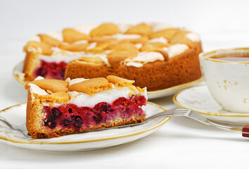 Homemade berry pie with meringue and cookies on white wooden table. Shallow focus.