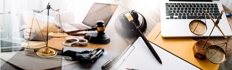 Justice and law concept.Male judge in a courtroom with the gavel, working with, computer and docking keyboard, eyeglasses, on table in morning light