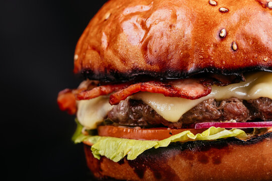Juicy and sliced ​​burger with meat cutlet close up. on a black background.