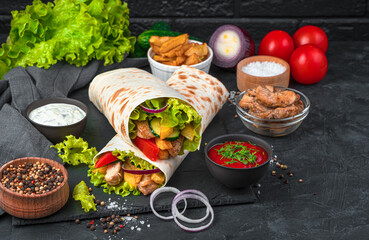 Shawarma and ingredients on a black background.