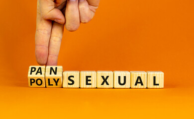 Pansexual or polysexual symbol. Doctor turns wooden cubes and changes the word 'polysexual' to 'pansexual'. Beautiful orange background, copy space. Social, pansexual or polysexual concept.