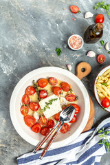 Trending fetapasta hot salad with baked tomatoes and feta. Preparation of ingredients for feta pasta. vertical image, place for text, top view