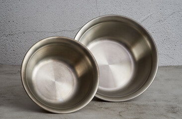 Two metallic bowls on light grey background