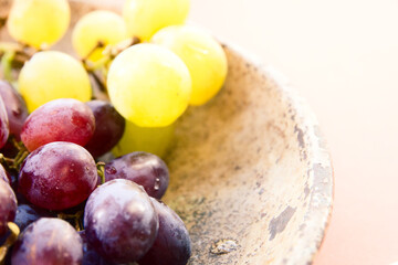 Close-up and selective focus of colorful table grapes in a vintage bowl