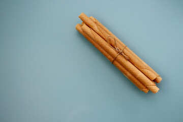 A bunch of wafer rolls on a gray-blue background. Long wafer rolls