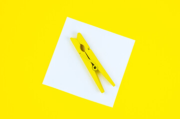 To Do List Sticker with yellow wooden clothespin. Close up of reminder note paper on the yellow background. Copy space. Minimalism, original and creative photo. Vertical Wallpaper for smartphone.