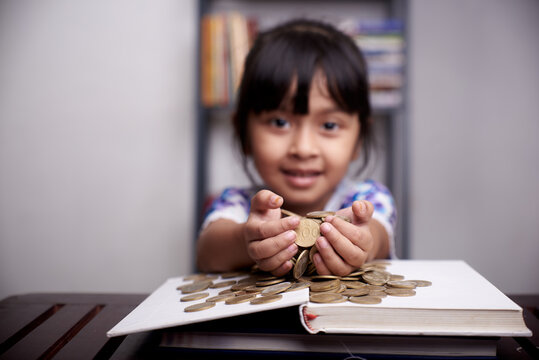 Pretty little Girl holding bunch of gold coins 