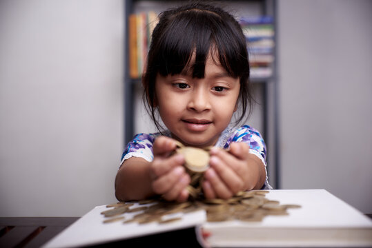 Pretty little Girl holding bunch of gold coins 