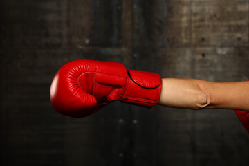 Hand with red boxing glove punching
