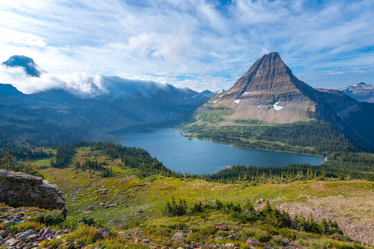 Hidden Lake and pyramid-shaped Bearhat Mountain in Glacier National Park, Montana, USA. Early morning light and scattered clouds above alpine valley in American Rockies. Hiking in Rocky Mountains