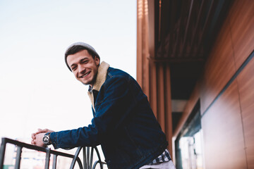 Fototapeta na wymiar Smiling man standing near railing during break