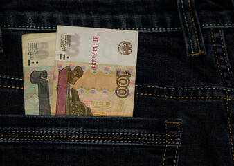 money in your pocket. Russian rubles. bills of 100 and 50 rubles in a trouser pocket. jeans pants, money in my pocket. business, trade or financial transactions, fraud, corruption and bribery. close