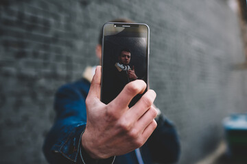 Anonymous man demonstrating smartphone screen with selfie