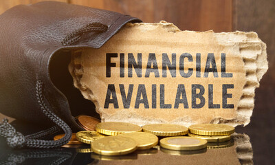 On the table is a bag of money from which sticks out cardboard with the inscription - FINANCIAL AVAILABLE