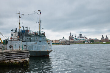 Naklejka premium old ship on the background of the Orthodox Church. Solovki Island, Russia