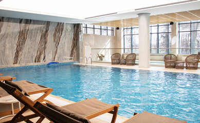 indoor pool with relaxation area - sun loungers and wicker chairs
