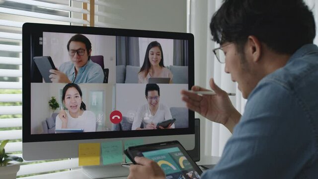 Asia business man talking in video conference.Asian team using laptop and tablet online meeting in video call.Working from home, Working remotely and Self isolation at home