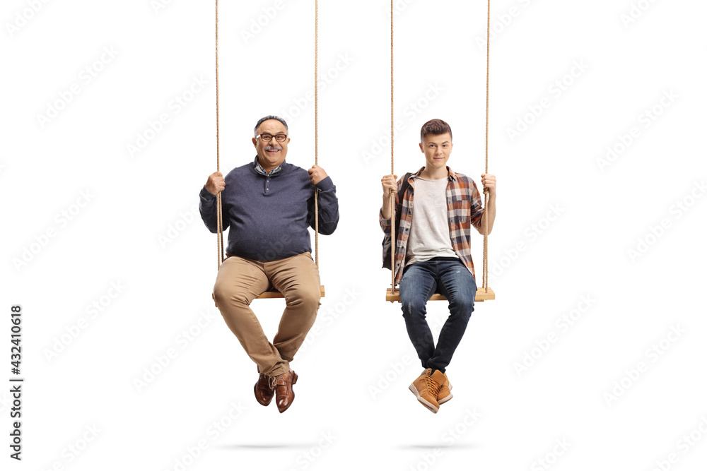 Wall mural Father and teenage student son sitting on wooden swings