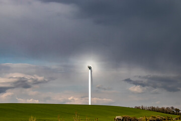 A single wind turbine generating power in a field in rural Cambridgeshire, UK