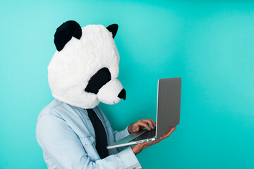 Happy man in panda mask using a laptop - Education online concept