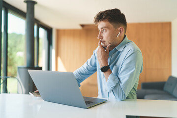 Fototapeta premium Successful business man working from home with laptop and smartphone