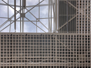 Roof metal trusses in the shopping center. Sky, lines, transparent roof