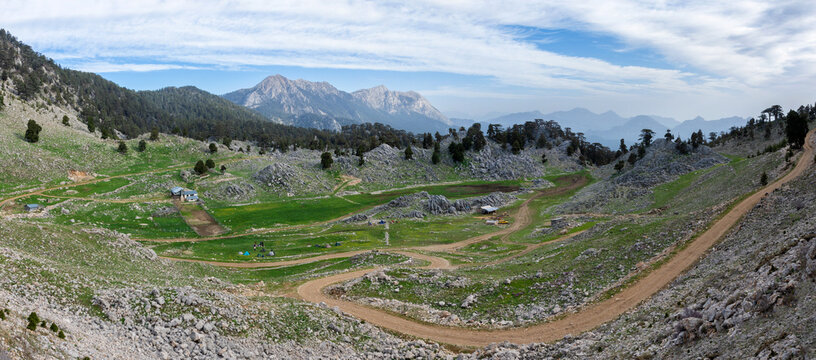 Alpine farm on Chukur Yayli. A huge valley in the mountains is surrounded by rocks. Panoramas of the Lycian trail in Turkey.