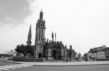 Fototapeta na wymiar Parish enclosure (parish church elaborately decorated with sculpture groups and surrounded by an entirely walled churchyard) in Pleyben. Brittany, France. Black white historic photo.