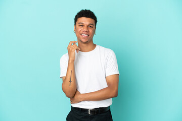 Young African American man isolated on blue background laughing