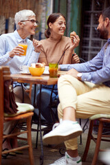 A group of friends of different generations talking while they have a drink in the bar. Leisure, bar, friendship, outdoor