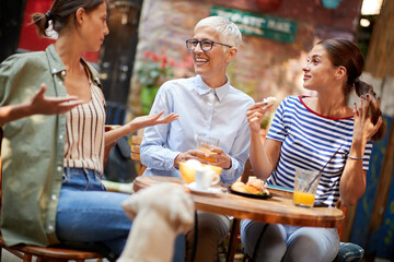 A group of female friends of different generations talking in the bar. Leisure, bar, friendship, outdoor