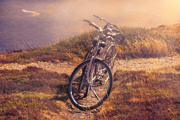 Two bicycles on the hill over the sea in sunny day and a boat sailing at background. Breton coast...