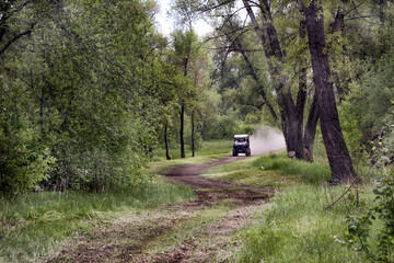 A cross country quad bike going thru a forest at high speed.