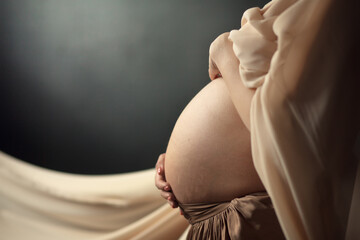 A belly of a pregnant woman. Image with selective focus and toning