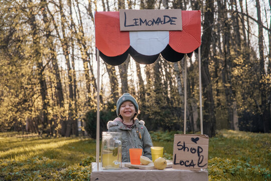 toddler girl selling lemonade in kids little lemonade stand