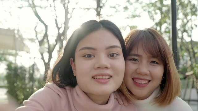 Young happy asian pretty girls couple friend blogger take selfie look at camera with smile face in the city street. Close up portrait funny joyful young women, Outdoor holiday vacation concept.