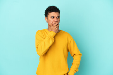 Young African American man isolated on blue background having doubts and with confuse face expression