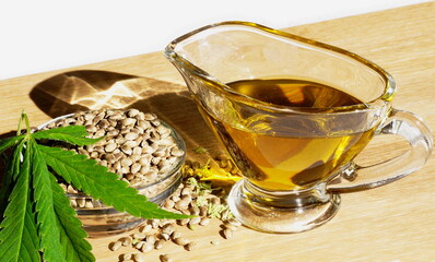 Hemp oil.
Leaves and seeds, oil in a glass jug on a cutting board.