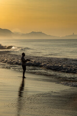 Pescador en la playa al amanecer