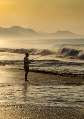 Fototapeta na wymiar Pescador en la playa al amanecer