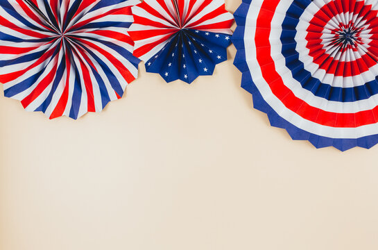 Decorations for 4th of July day of American independence, flag, candles, straws, paper fans. USA holiday decorations on a beige background, top view, flat lay	